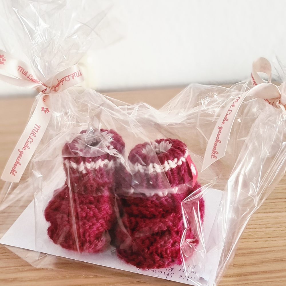 Gestrickte Babyschuhe als Geschenk verpackt für Geburt oder Babyshower