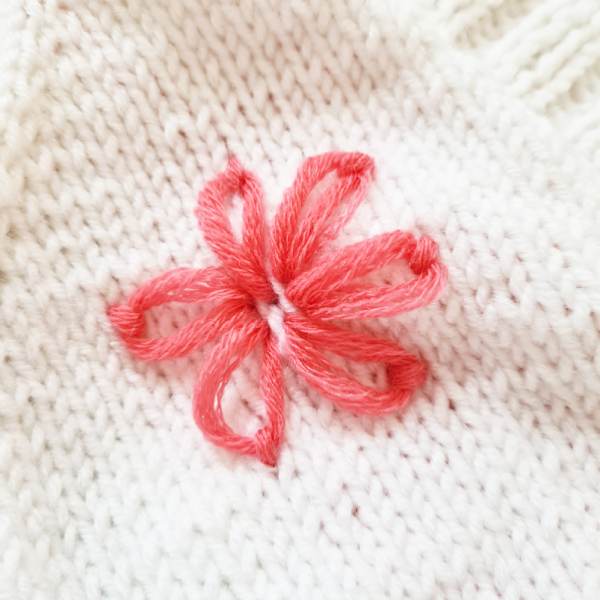 Kleine gestickte Blume auf Pullover oder Cardigan